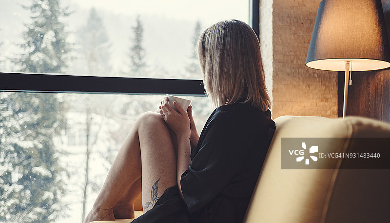 年轻女人喝着咖啡做白日梦图片素材