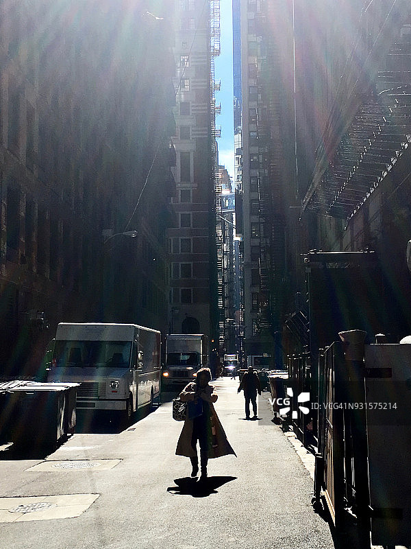 在寒冷的冬日，穿过芝加哥市中心小巷的剪影女人图片素材