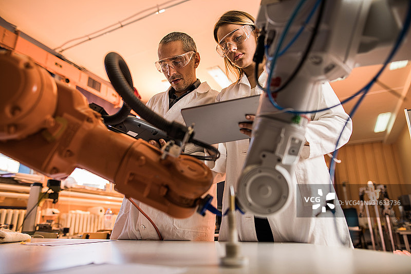 科学家在实验室合作研究机械臂图片素材