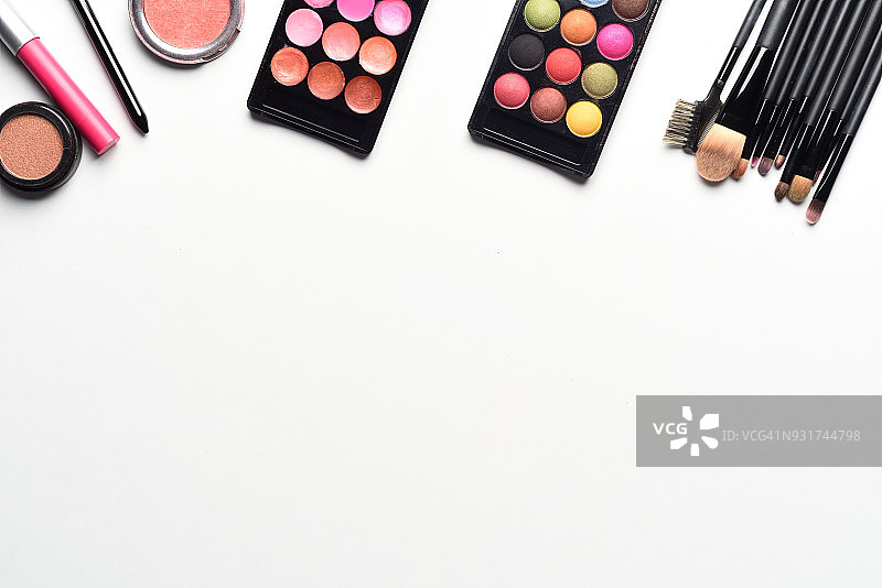 白色背景上口红、睫毛膏、腮红、唇彩和粉饼化妆品套装俯视图图片素材