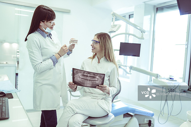 牙医和护士在牙科诊所检查患者X光片图片素材