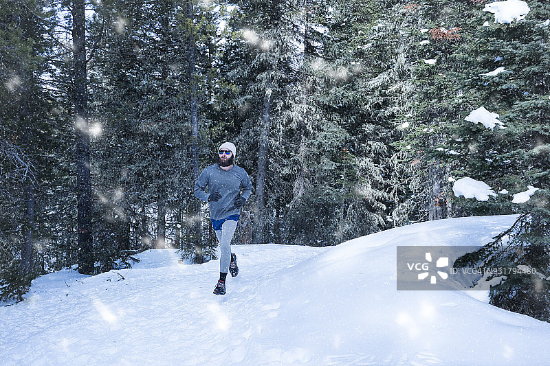 男人在森林的降雪中奔跑图片素材