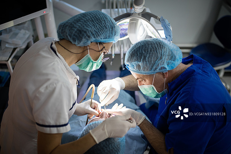 牙医检查患者并进行牙科手术图片素材