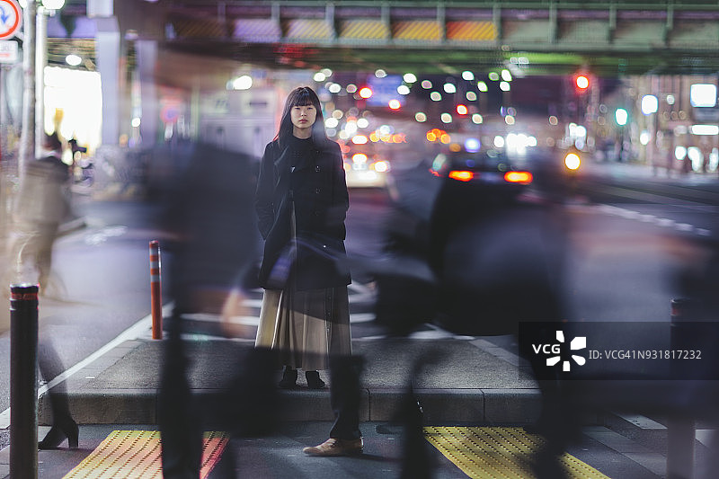 在东京夜晚的街道上站立的女人图片素材