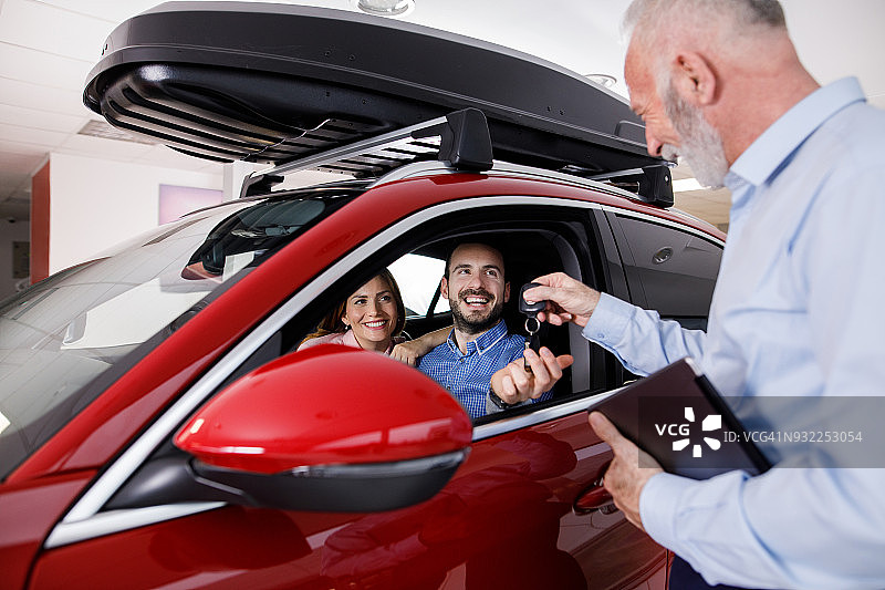 情侣从汽车销售员那里收到新车钥匙图片素材