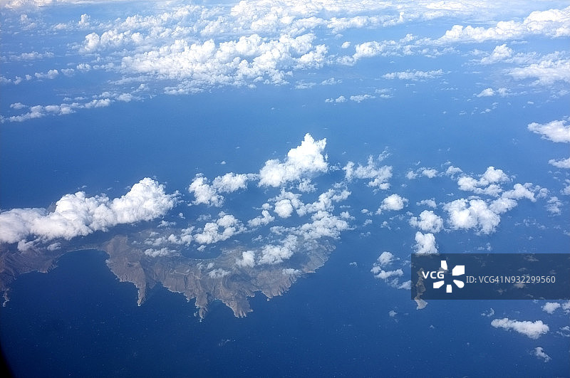 飞行视角：希腊群岛上空，晴朗的天空和稀疏的云朵图片素材