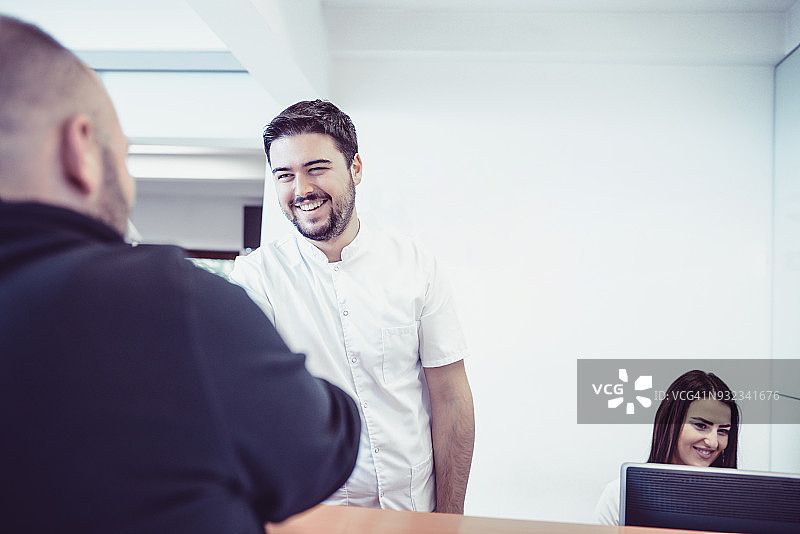 年轻医生和助手在诊所接待处预约图片素材