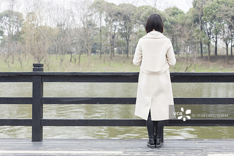 站在人行天桥上的美丽女性的后视图图片素材