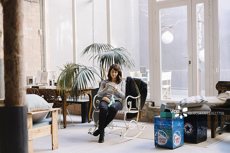 女人坐在椅子上织毛衣图片素材