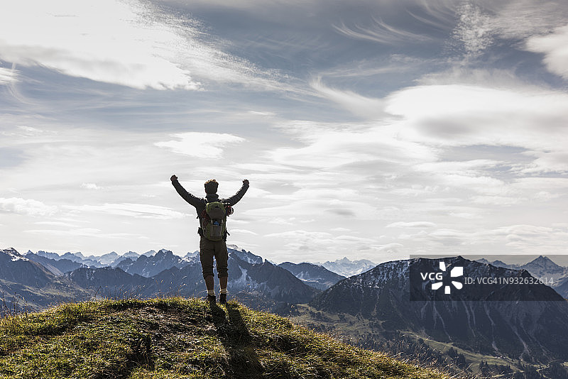 奥地利蒂罗尔：站在山景中欢呼的年轻人图片素材
