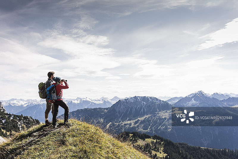 奥地利蒂罗尔州一对年轻夫妇站在山景中欣赏风景图片素材