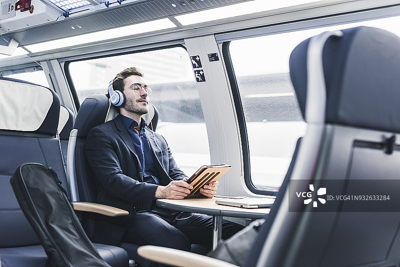 在火车上放松听音乐的商人图片素材