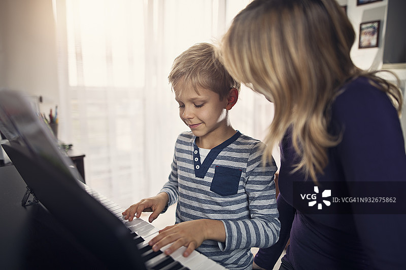 小男孩和母亲一起练习钢琴图片素材