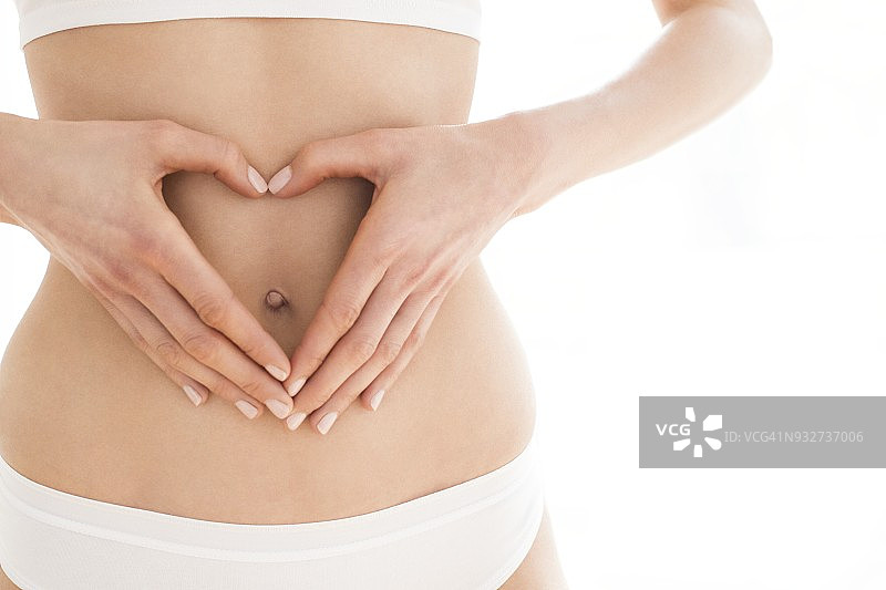 女人双手在腹部摆出心形图片素材