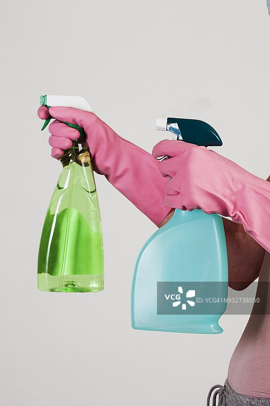 戴着手套的手拿着清洁用品图片素材