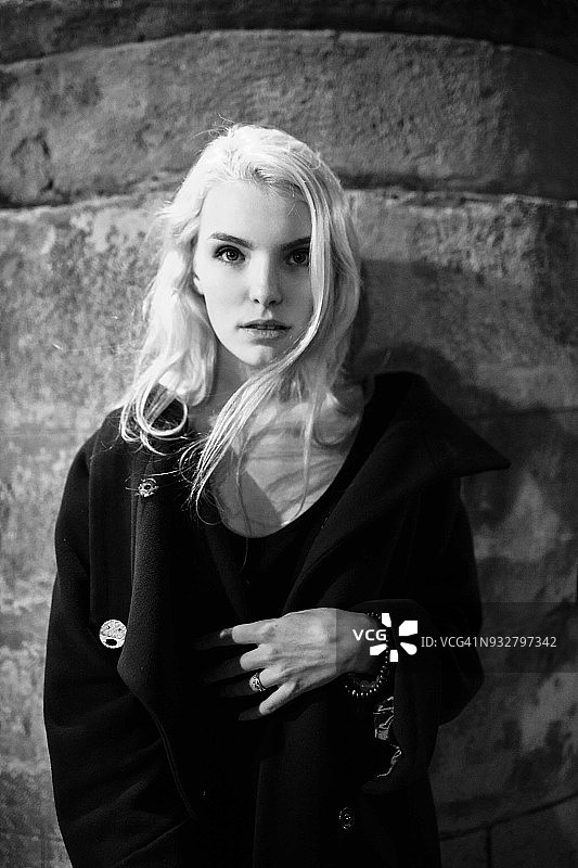 年轻女子靠墙站立图片素材