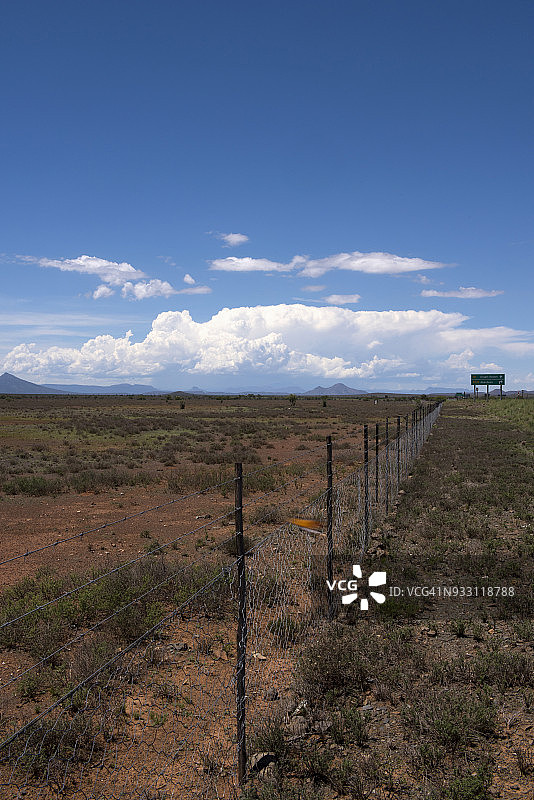 卡鲁景观：绵羊栅栏线延伸至地平线，傍晚时分在阿伯丁和格拉夫里内特之间的N9公路上看到的雷暴，东开普省图片素材