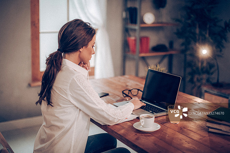 用笔记本电脑完成日常工作的女人图片素材