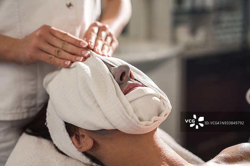 在美容院用毛巾敷脸的女人图片素材