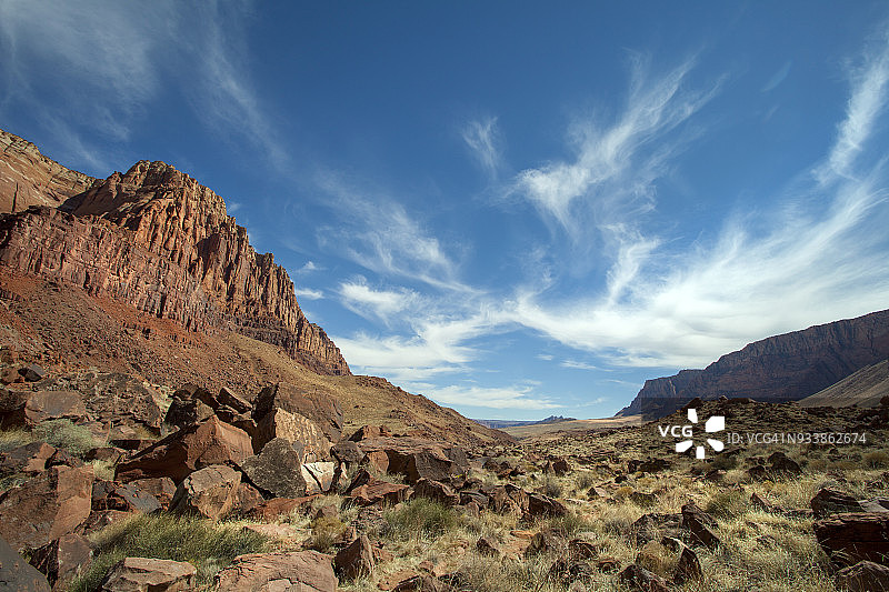 壮丽天空和红色岩石沙漠景观中的徒步路线图片素材