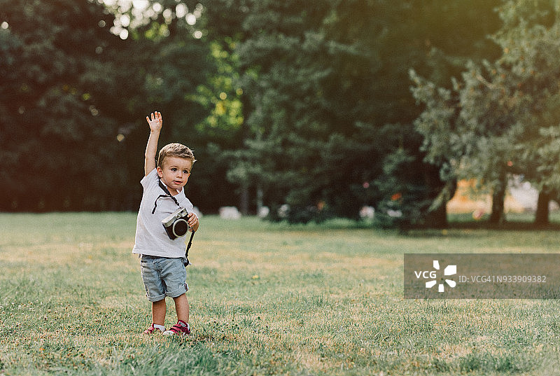 在公园里使用复古相机的小男孩图片素材
