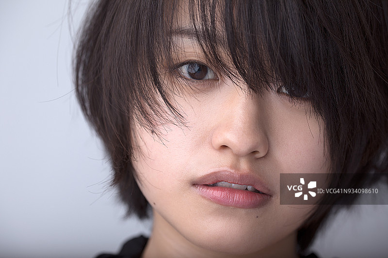 灰色背景前的年轻女人图片素材