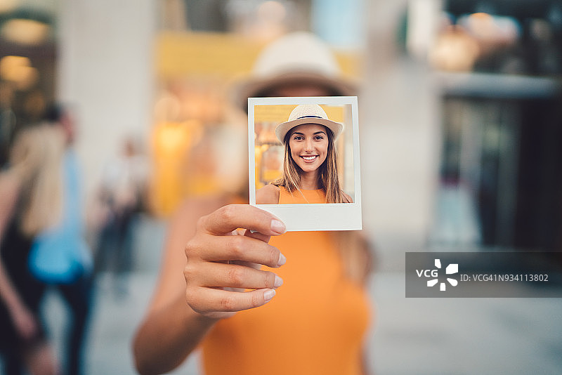 女人向镜头展示即时照片图片素材
