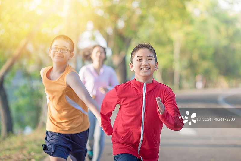 家庭运动快乐活跃的母亲和孩子在户外慢跑，在森林里跑步图片素材