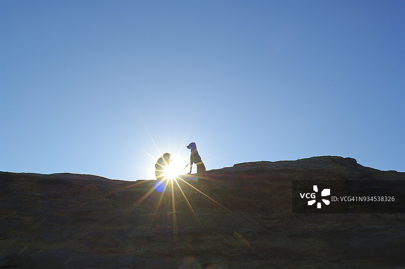 俄勒冈州基万达角，阳光下的女子与狗剪影图片素材