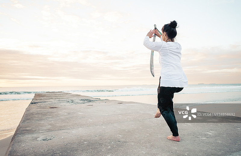 夕阳下练习吴式太极剑的女子图片素材