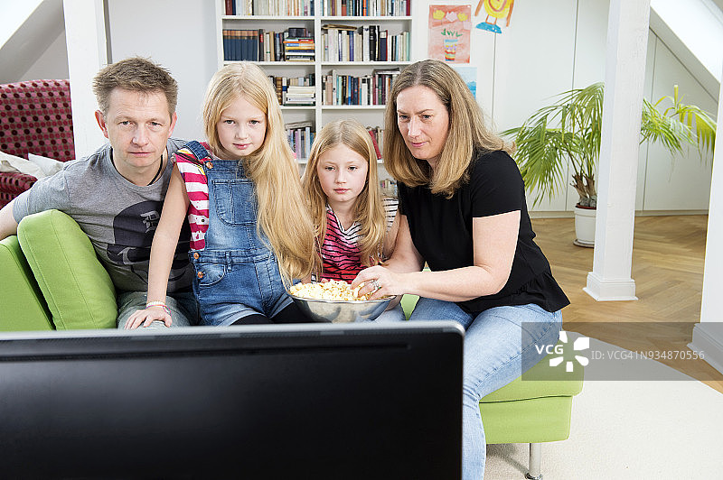 一家人看电视上的足球世界杯图片素材