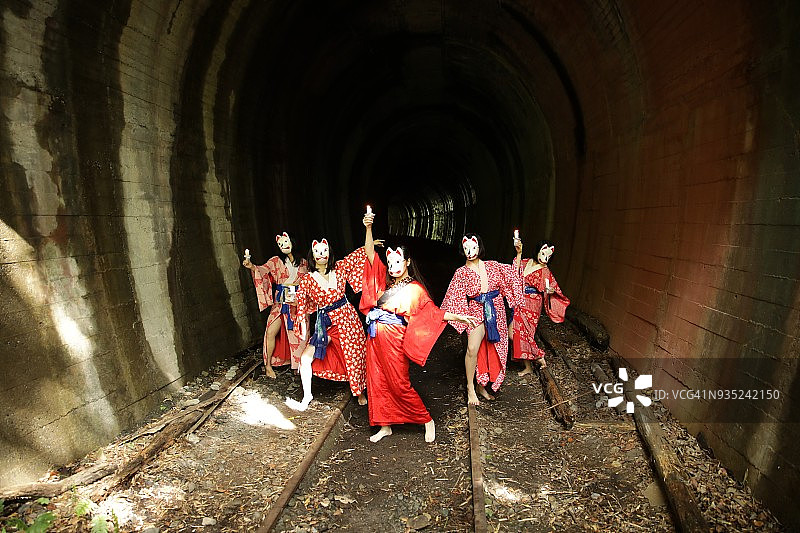 隧道前戴着面具的五名和服女子图片素材