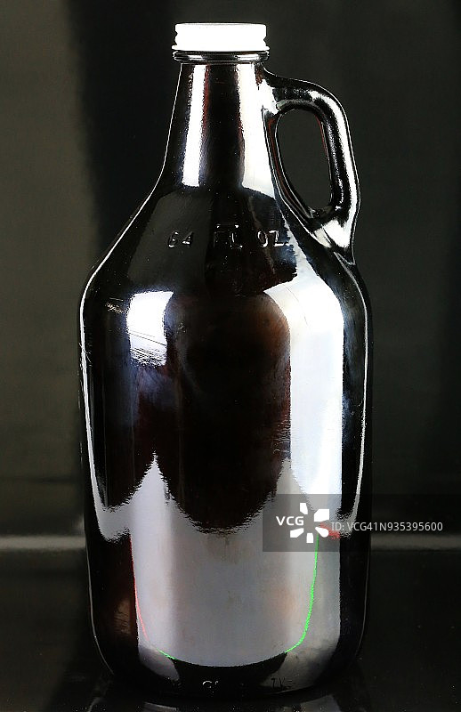 黑色背景上的琥珀色啤酒壶图片素材