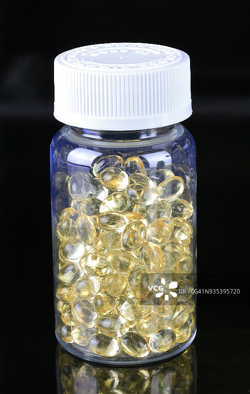 黑色背景上的维生素D液体药丸图片素材