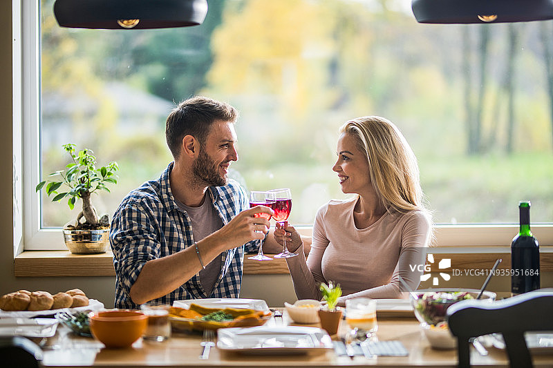 幸福情侣在家午餐时举杯红酒庆祝图片素材