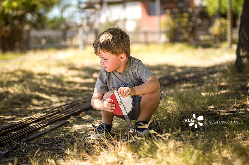 站在蒸汽火车轨道上的小男孩图片素材