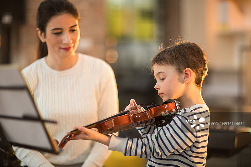 漂亮的女老师教小男孩拉小提琴图片素材