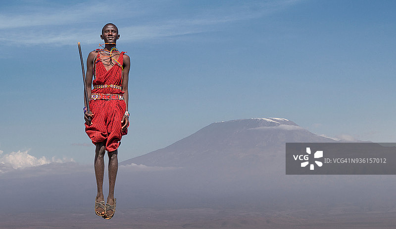 穿着传统服装的马赛男人在乞力马扎罗山前跳跃，肯尼亚裂谷安博塞利图片素材
