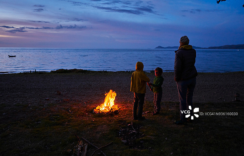 在营火旁看着湖景的母子，后视图，玻利维亚奥鲁罗科帕卡巴纳图片素材