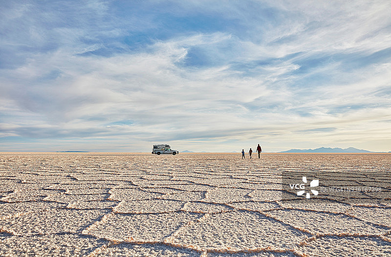 母子走过玻利维亚乌尤尼盐沼，背景是休闲车图片素材