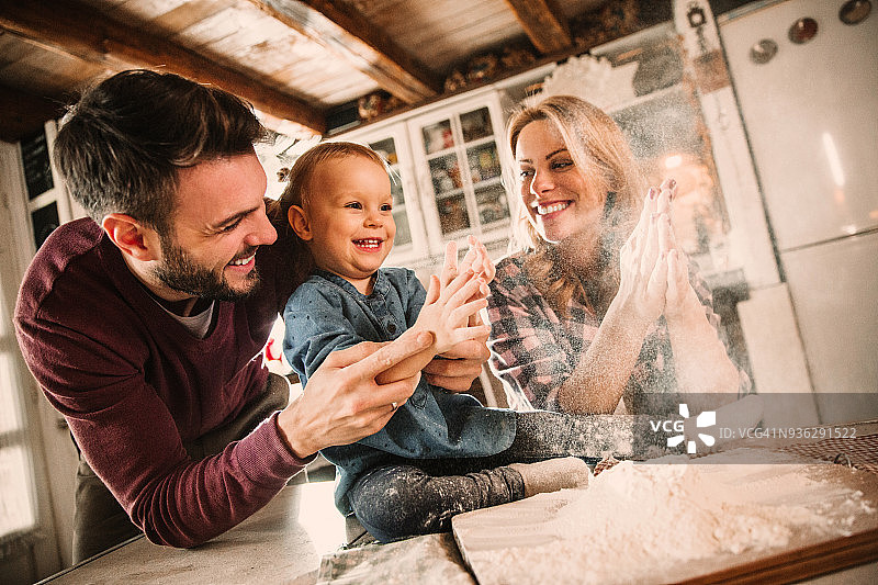 年轻浪漫情侣和女儿在厨房准备午餐意大利面图片素材