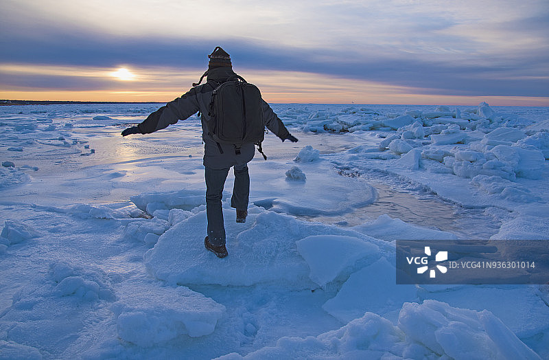美国马萨诸塞州科德角伊斯ham黄昏时分男子在海冰上保持平衡图片素材