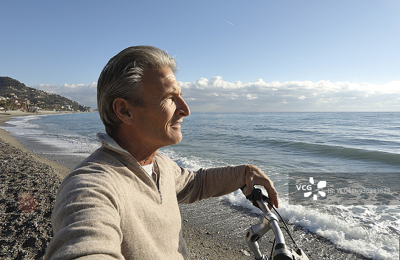 男人在海滩边骑自行车放松图片素材