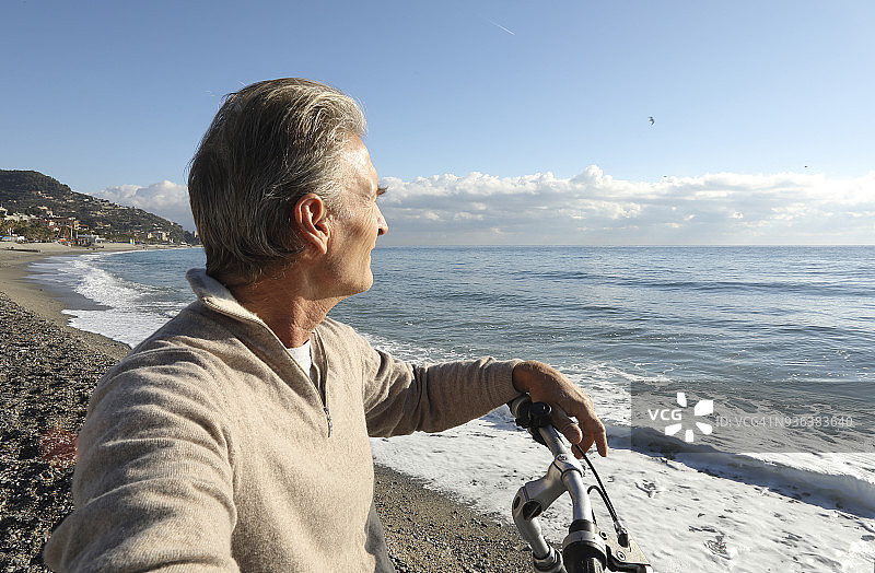 男人在海滩边骑自行车放松图片素材