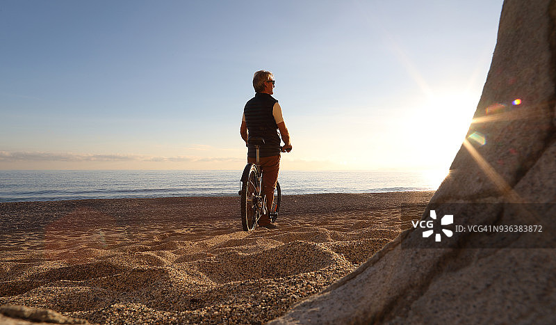 男人在海滩边骑自行车放松图片素材