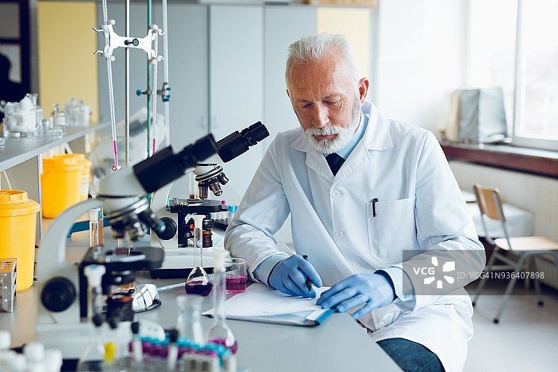在实验室用显微镜工作的科学家图片素材