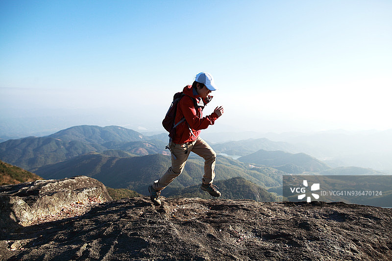 年轻男人在山脊上跑步图片素材