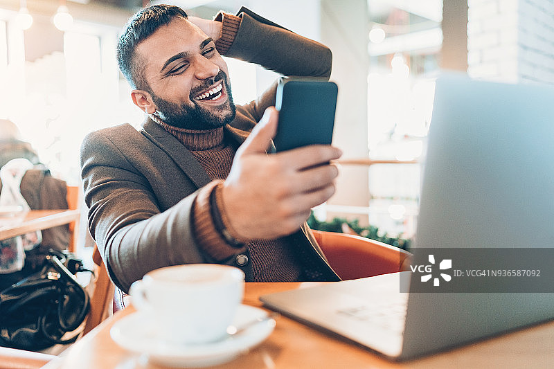 微笑的年轻商务男士在咖啡馆自拍图片素材