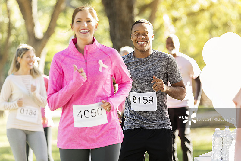 慈善跑参赛者冲过终点线图片素材