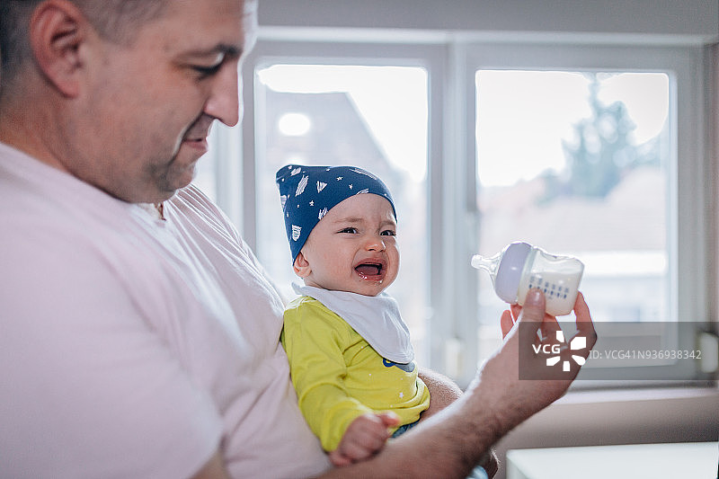 父亲用奶瓶喂他的男婴图片素材